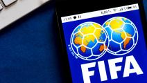 In this photo illustration a FIFA logo seen displayed on a...