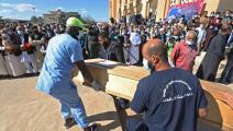 دفن جثة من مقبرة جماعية في ترهونة في ليبيا (فرانس برس)