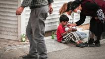 مسنّة تركية تطعم طفلاً سورياً في أنقرة (توناهان تورهان/ Getty)