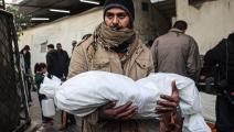 رجل فلسطيني يحمل جثة طفل شهيد في غزة (سعيد الخطيب/ فرانس برس)
