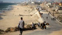 فلسطينيون يسيرون بالقرب من شاطئ البحر في قطاع غزة، 18 مايو 2024 (مجدي فتحي/ Getty)