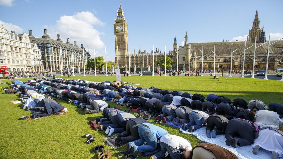 مسلمون بريطانيون يؤدون الصلاة أمام البرلمان (الأناضول)