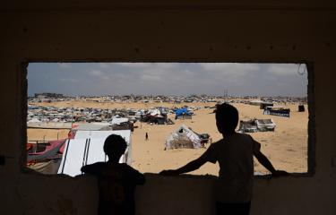 أطفال يشاهدون الدخان يتصاعد جراء الغارات الإسرائيلية شرق رفح 13 مايو 2024 (Getty)