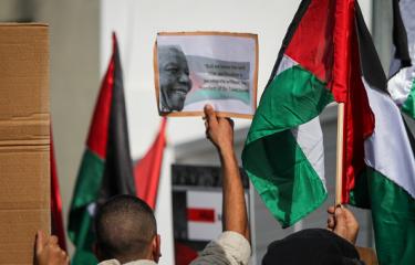 تونسيون يحملون صورة نيسلون مانديلا خلال تظاهرة أمام سفارة جنوب أفريقيا في تونس تشكر تحركاتها، 11/1/2024 (حسن مراد/Getty)