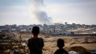 طفلان يشاهدان الدخان المتصاعد شرق رفح جنوب غزة جراء غارات الاحتلال (فرانس برس)