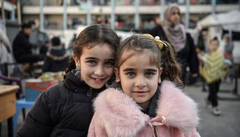 طفلتان فلسطينيتان في باحة مدرسة برفح حوّلها العدوان إلى ملجأ، 16 كانون الثاني/ يناير 2024 (Getty)