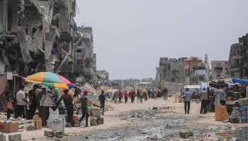 فلسطينيون يتسوقون بين الدمار في خانيونس، في 28 مايو 2024 (الأناضول)