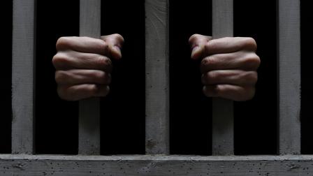 صورة تعبيرية تبيّن قضبان زنزانة سجن وسجيناً (Getty)