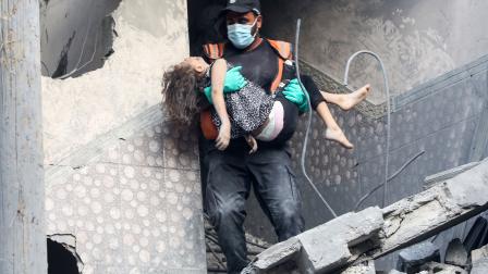 الدفاع المدني الفلسطيني ينقذ طفلة فلسطينية بعد تدمير طائرات الاحتلال لمنزلها (أحمد حسب الله/Getty)