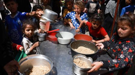 أطفال يحصلون على قليل من الطعام في رفح (محمد عابد/ فرانس برس)