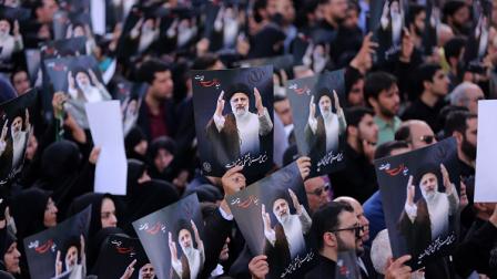 إيرانيون يحملون صوراً لرئيسي وعبد اللهيان في طهران