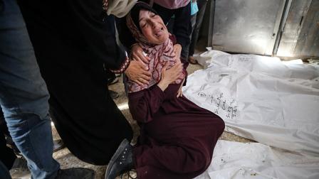 امرأة تبكي أحد أقاربها الذي استشهد جراء قصف إسرائيلي على غزة (Getty)